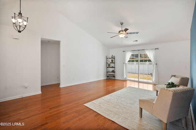 living area with wood-type flooring, lofted ceiling, and ceiling fan with notable chandelier