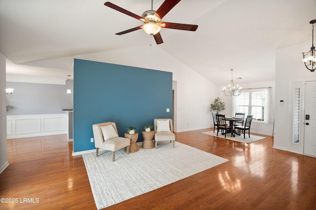 living area with dark hardwood / wood-style floors, ceiling fan with notable chandelier, and high vaulted ceiling