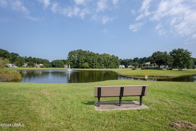 surrounding community with a water view and a yard