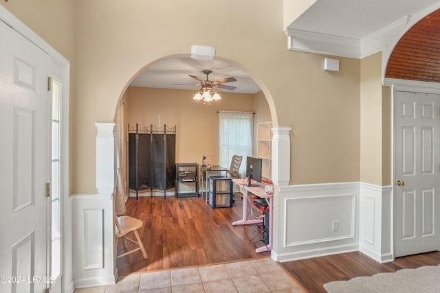 foyer entrance with crown molding, tile patterned floors, and ceiling fan