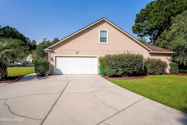 view of property exterior with a garage and a lawn