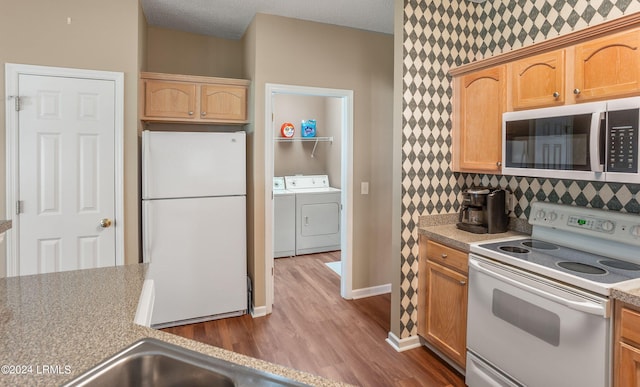 kitchen with washer and dryer, backsplash, hardwood / wood-style flooring, white appliances, and a textured ceiling