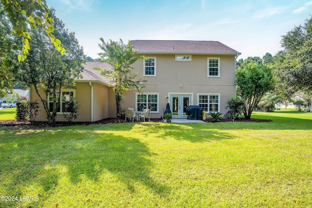 back of house with french doors and a yard