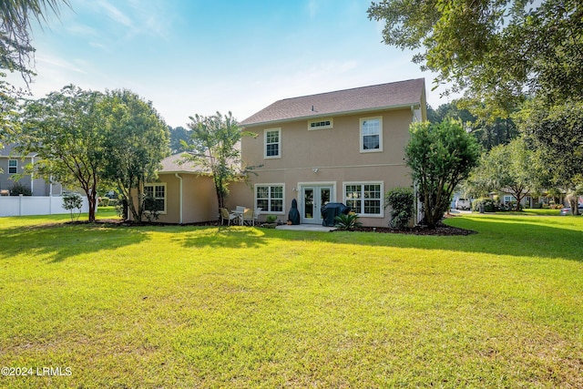 rear view of property with french doors and a yard