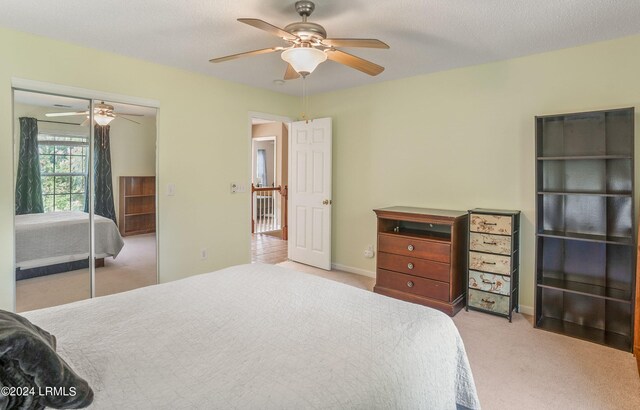 carpeted bedroom with a textured ceiling, a closet, and ceiling fan