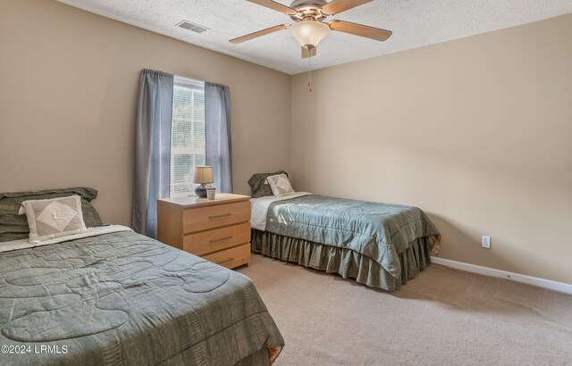 carpeted bedroom with a textured ceiling and ceiling fan