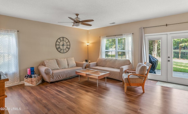 living room with wood-type flooring, ceiling fan, a textured ceiling, and french doors