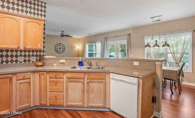 kitchen featuring sink, decorative light fixtures, kitchen peninsula, dishwasher, and decorative backsplash