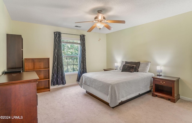 carpeted bedroom with a textured ceiling and ceiling fan