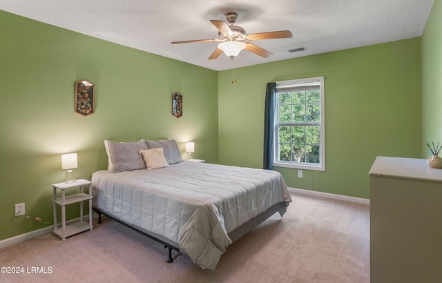 carpeted bedroom featuring a textured ceiling and ceiling fan