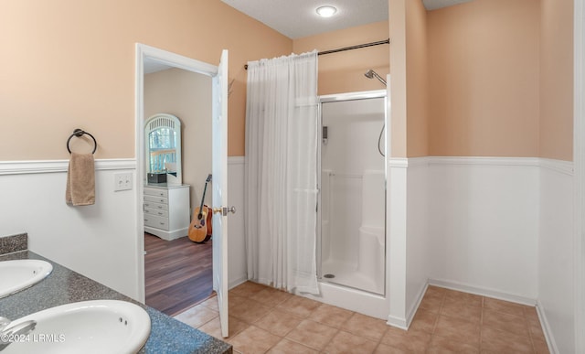 bathroom with vanity, curtained shower, tile patterned floors, and a textured ceiling