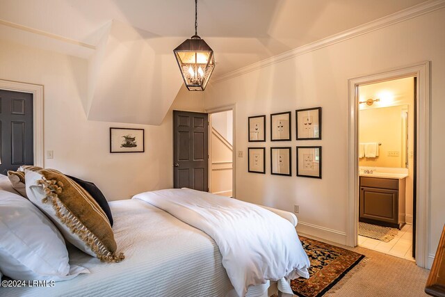 bedroom with ensuite bathroom, a chandelier, light colored carpet, and crown molding