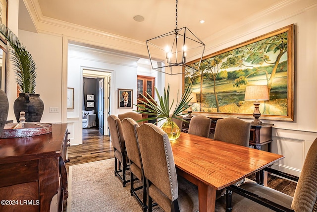 dining area featuring ornamental molding, hardwood / wood-style floors, and a notable chandelier