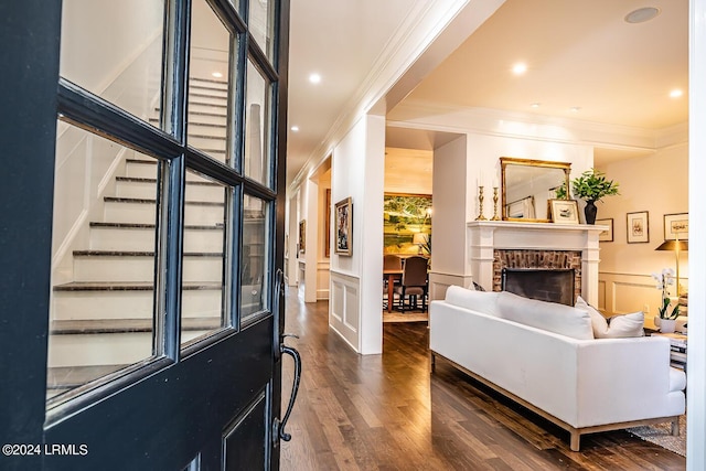 living room featuring crown molding, dark hardwood / wood-style floors, and a fireplace