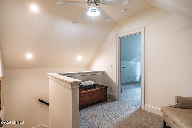 hall featuring light carpet and vaulted ceiling