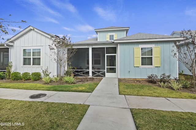 bungalow-style home featuring a front yard and a sunroom