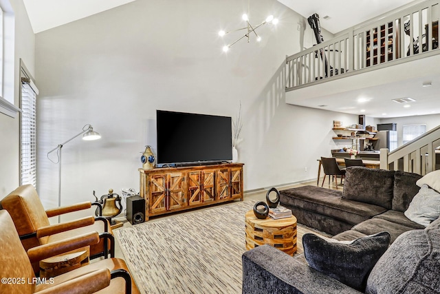610 E Ave, Bluffton, SC 29910 - living room featuring stairway, a notable chandelier, baseboards, and a towering ceiling