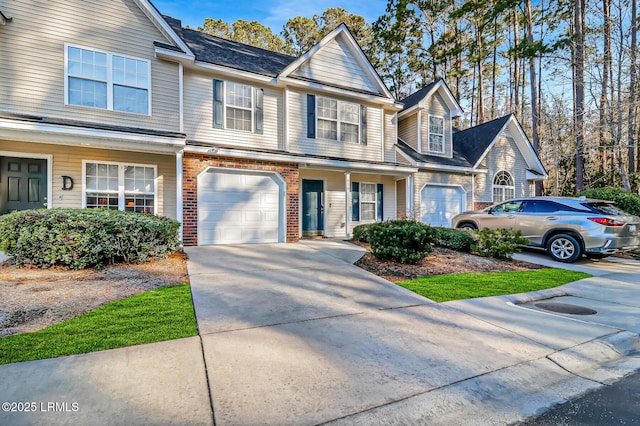 610 E Ave, Bluffton, SC 29910 - townhome / multi-family property featuring an attached garage, brick siding, and driveway