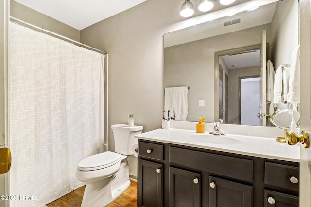610 E Ave, Bluffton, SC 29910 - full bathroom with vanity, a shower with shower curtain, wood finished floors, visible vents, and toilet