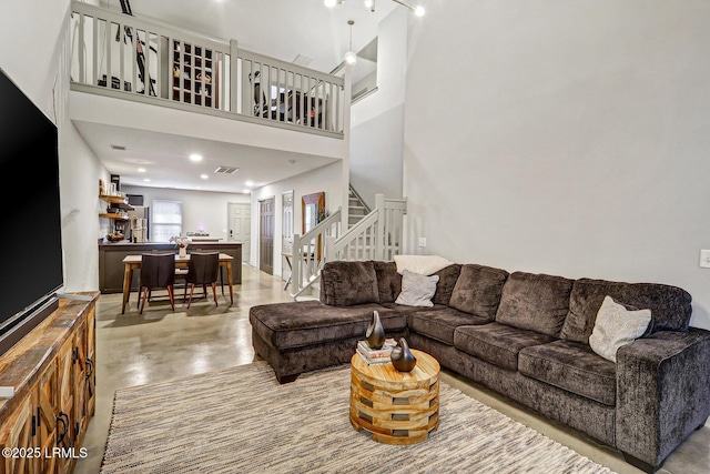610 E Ave, Bluffton, SC 29910 - living room with visible vents, concrete floors, stairway, recessed lighting, and a towering ceiling
