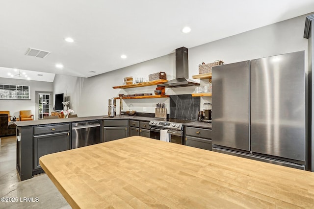 610 E Ave, Bluffton, SC 29910 - kitchen with visible vents, appliances with stainless steel finishes, a peninsula, wall chimney exhaust hood, and open shelves