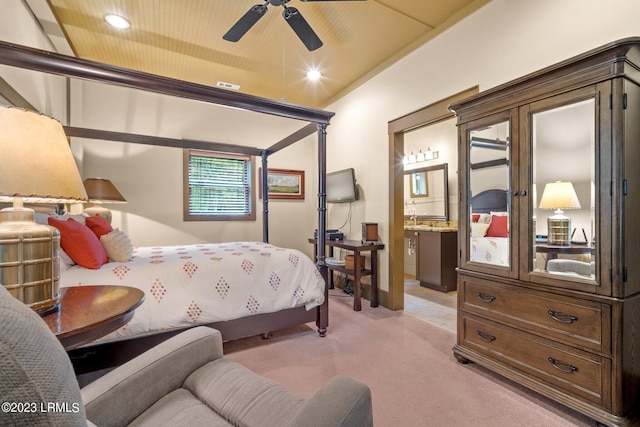 bedroom with light colored carpet, ceiling fan, and ensuite bathroom