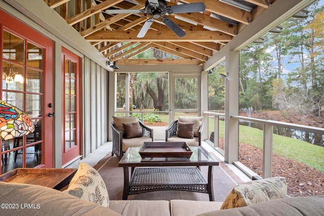 sunroom with plenty of natural light, vaulted ceiling with beams, and ceiling fan