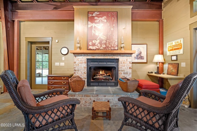 living room with a brick fireplace and wood walls