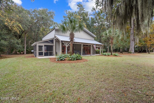 back of property featuring a sunroom and a yard