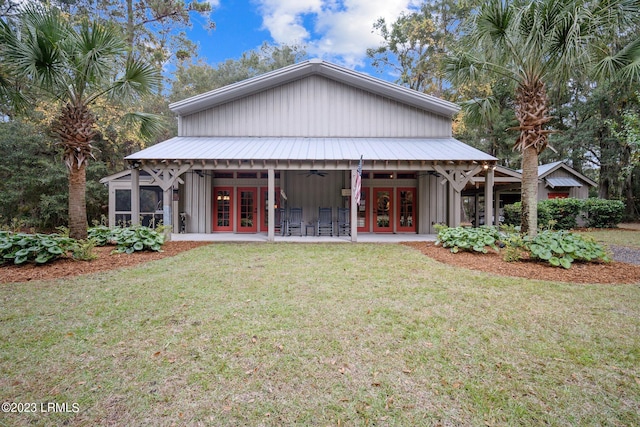 rear view of property with french doors, ceiling fan, a sunroom, and a lawn