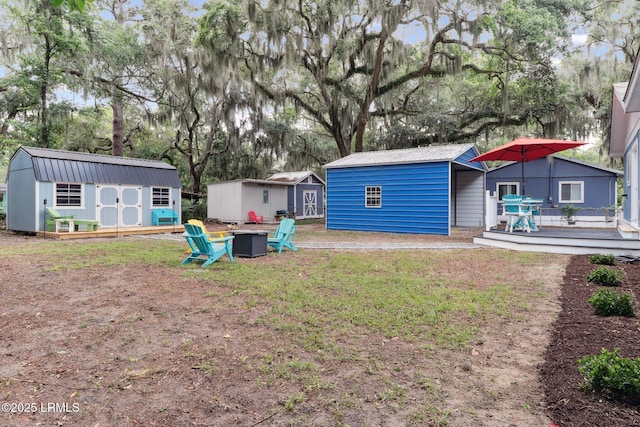 1617 Paris Ave W, Port Royal, SC 29935 - view of grassy yard with a fire pit, a wooden deck, and view of scattered trees