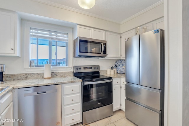 kitchen featuring appliances with stainless steel finishes, white cabinetry, light tile patterned floors, crown molding, and a textured ceiling