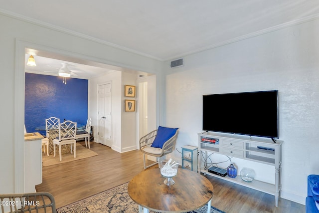 living room featuring crown molding, wood-type flooring, and ceiling fan