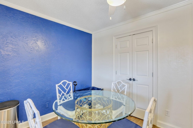 dining space with ceiling fan, wood-type flooring, ornamental molding, and a textured ceiling