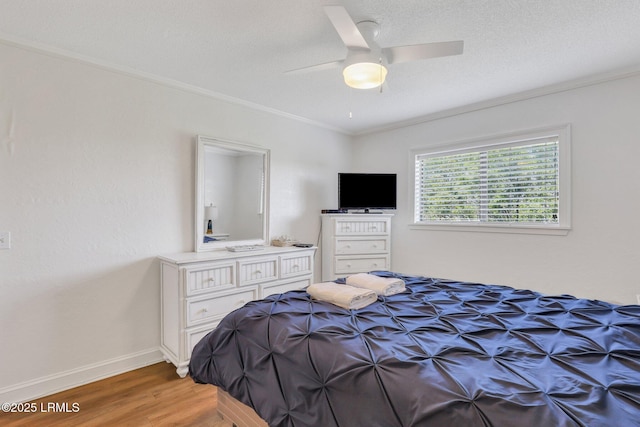 bedroom featuring crown molding, ceiling fan, hardwood / wood-style floors, and a textured ceiling