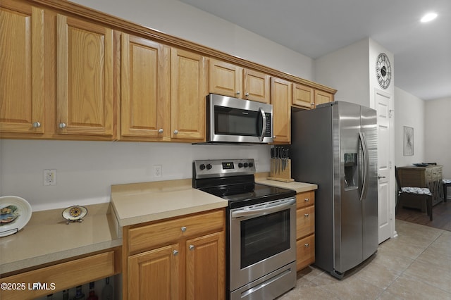 193 Landing Ln, Bluffton, SC 29909 - kitchen with stainless steel appliances, light countertops, light tile patterned flooring, and brown cabinetry