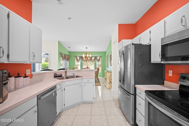 50 Padgett Dr, Bluffton, SC 29909 - kitchen with light tile patterned floors, a chandelier, a sink, light countertops, and stainless steel appliances