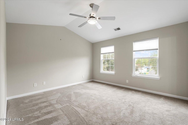 carpeted empty room featuring vaulted ceiling and ceiling fan