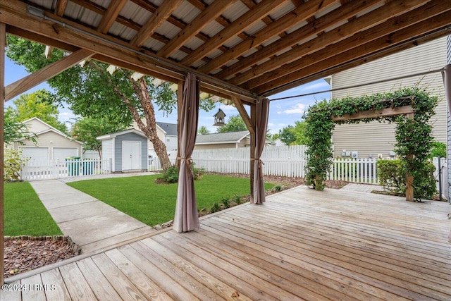 wooden deck with a storage shed, a yard, and a garage