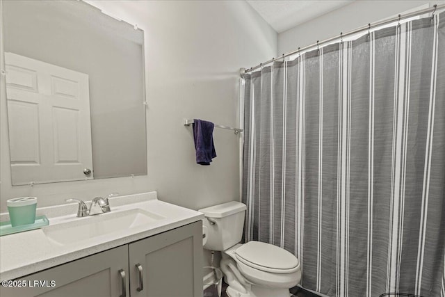 full bathroom featuring toilet, vanity, and curtained shower