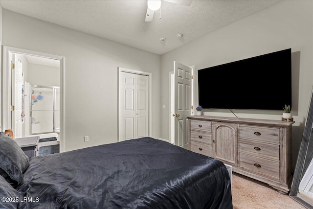 bedroom featuring a textured ceiling, ensuite bath, ceiling fan, light carpet, and a closet