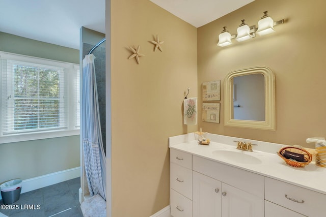 bathroom featuring curtained shower, tile patterned flooring, baseboards, and vanity