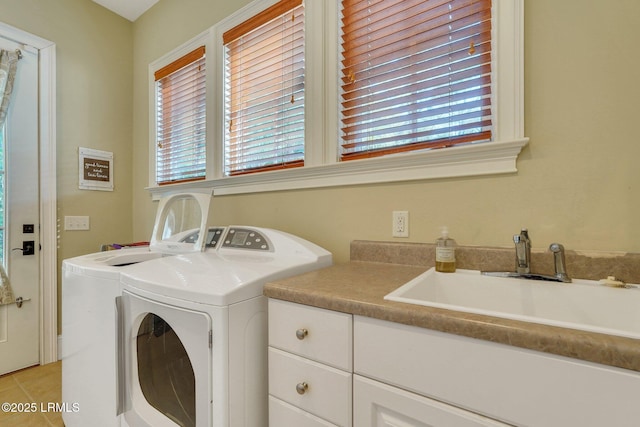 clothes washing area with a healthy amount of sunlight, washing machine and dryer, a sink, and light tile patterned flooring