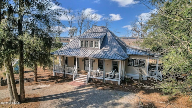 view of front of property featuring dirt driveway, metal roof, crawl space, a standing seam roof, and covered porch