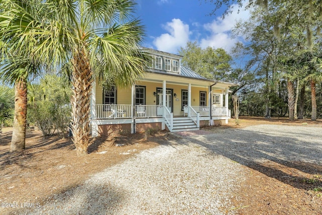 view of front of house with covered porch, metal roof, and driveway