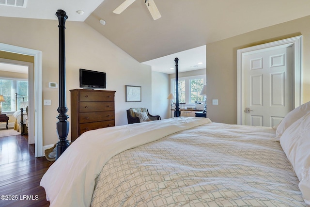 bedroom with baseboards, visible vents, a ceiling fan, dark wood finished floors, and vaulted ceiling