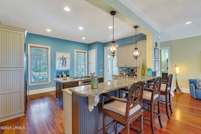 kitchen with cream cabinetry, dark wood finished floors, and baseboards