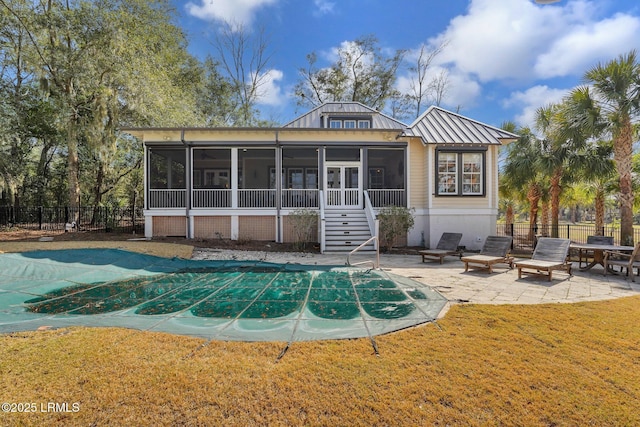 back of house featuring a sunroom, a patio, fence, and a lawn