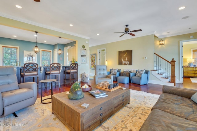 living room with light wood finished floors, stairway, and crown molding