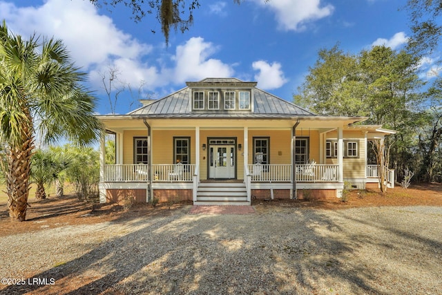 view of front of home featuring covered porch, metal roof, and crawl space